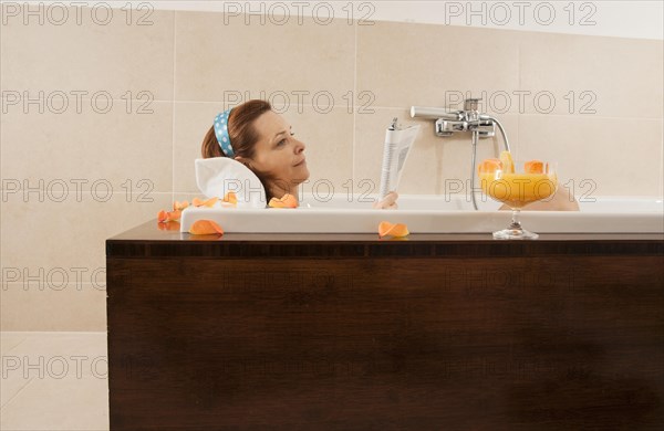 Woman reading in a bathtub