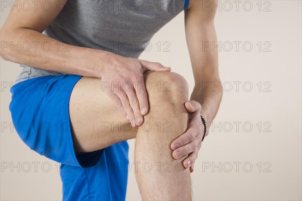 Young man examining his knee