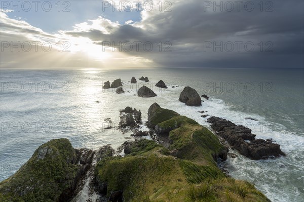 Cliffs rising from the Pacific with a rising sun