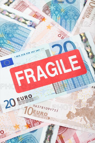 Euro banknotes with a 'Fragile' sticker