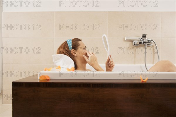 Woman checking her expression lines while bathing