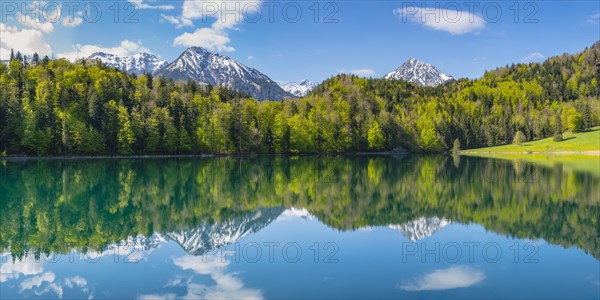 Mountains with snow remains are reflected in Alatsee