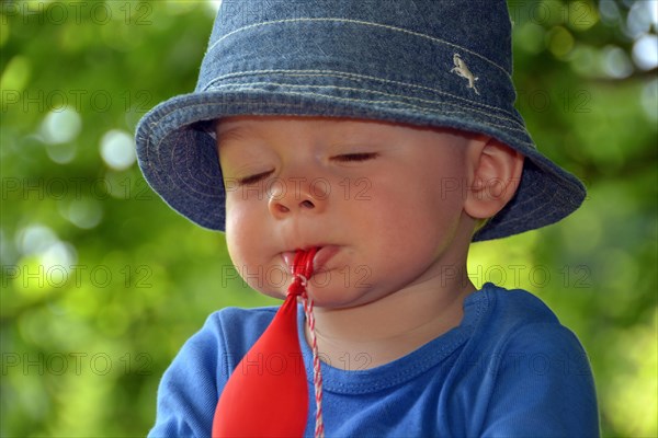 Toddler playing absent-minded with a balloon