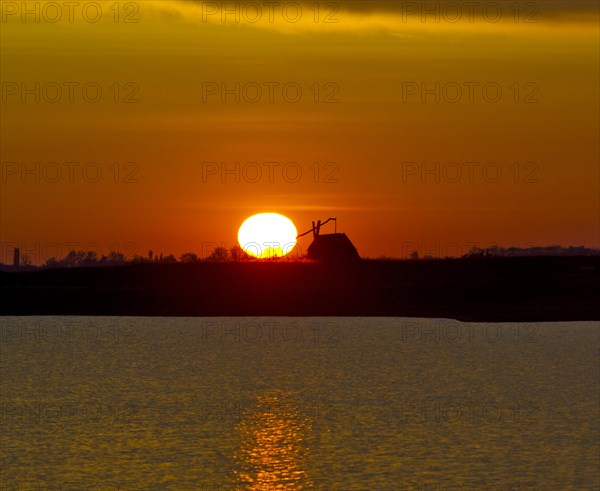 Sunrise with drawing well at Darscho-Lacke or Warmsee Lake