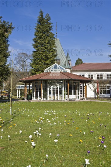 Historic Kurhaus with a pavilion and crocuses in the lawn