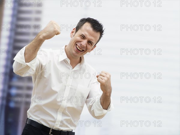 Businessman in an office cheering with clenched fists