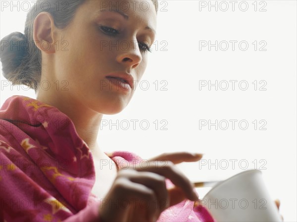 Woman wearing a bathrobe smoking a cigarette