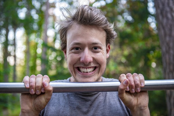 Young man doing pull-ups on a pull-up bar