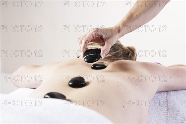Young woman being treated with hot stones