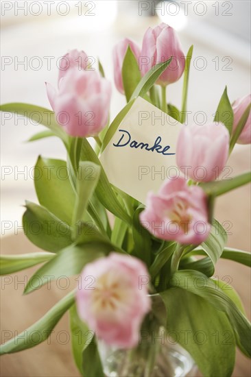 Tulips in vase with the note 'danke'