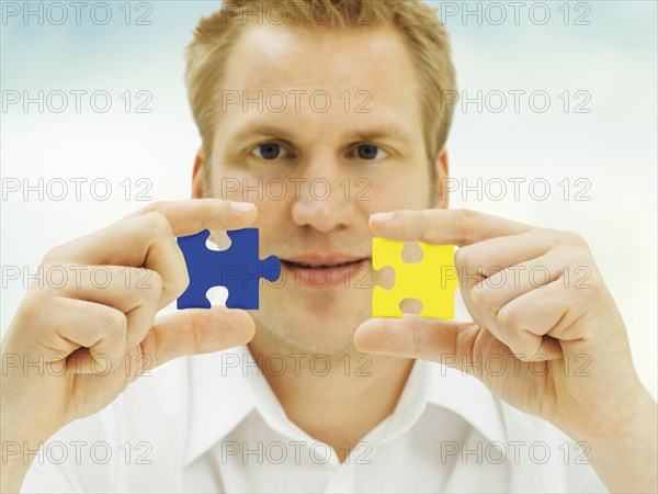 Man putting pieces of a jigsaw puzzle together