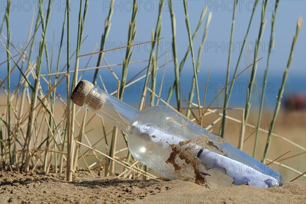 Message in a bottle in sand on a beach