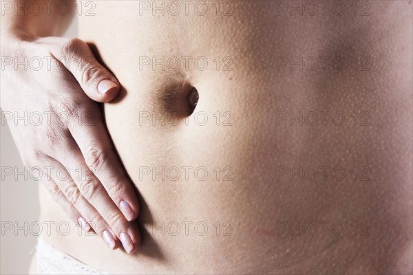 Young woman holding a hand on her aching stomach