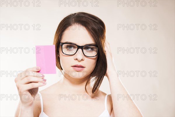 Young woman looking at herself in a cosmetic mirror