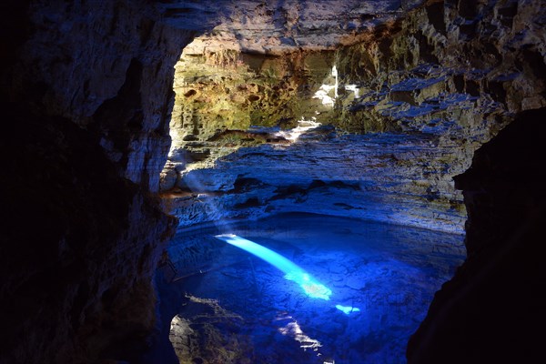 The colorful cave Poco Encantado with rays of light