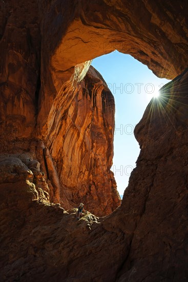 Hiker relaxing under the Double Arch