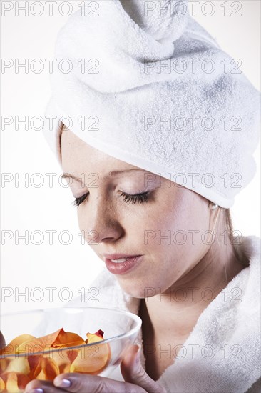 Young woman enjoying the fragrance of rose petals