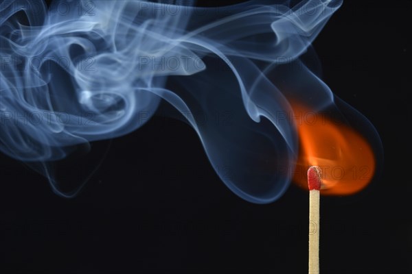 Lit matchstick with a flame and smoke