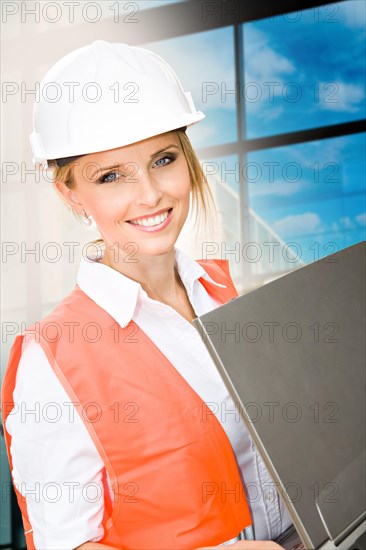 Young female constructor in front of a new building