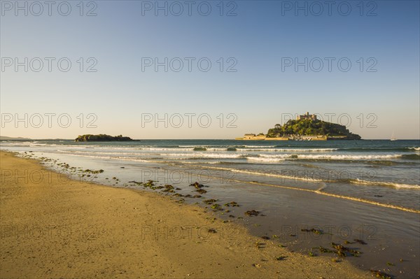 Sand beach with the island of St. Michael's Mount at high tide