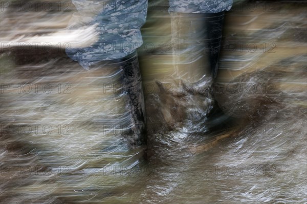 Walking with rubber boots in muddy terrain