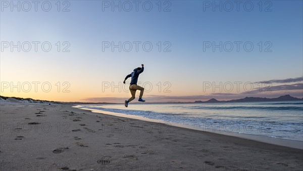 Young man jumps into the air