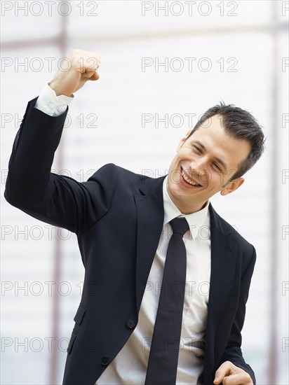 Businessman in an office cheering with a clenched fist