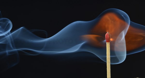 Lit matchstick with a flame and smoke