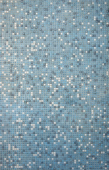 Mosaic wall with small white and turquoise tiles in a swimming pool
