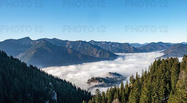 View of mountain peaks with fog over the valley