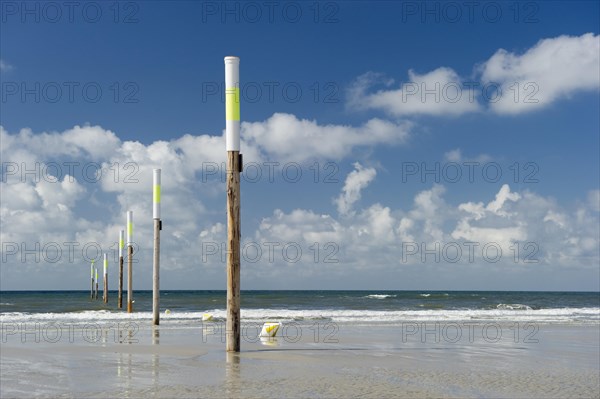 Beach and marker posts against the sky
