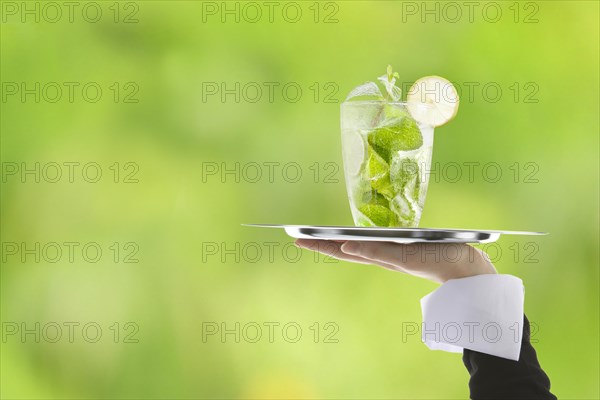 Hugo cocktail with lime and mint being served on a tray