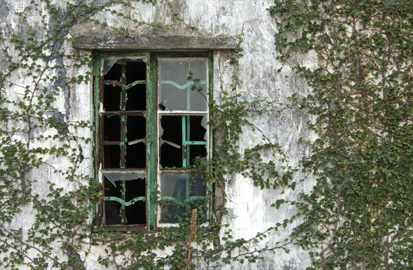 Broken window of an abandoned house in an abandoned village