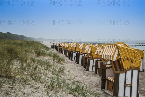 Roofed wicker beach chairs on the beach