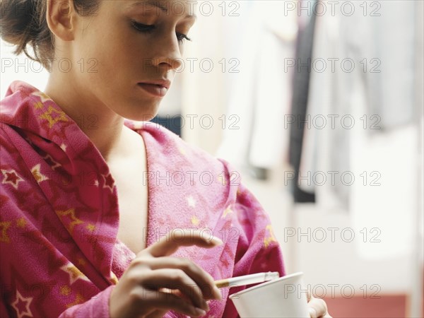 Woman wearing a bathrobe smoking a cigarette