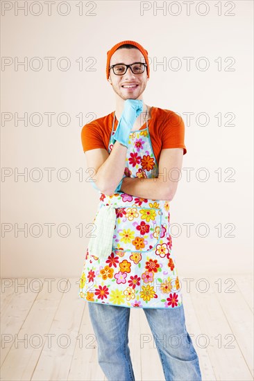 Young man wearing an apron and cleaning gloves