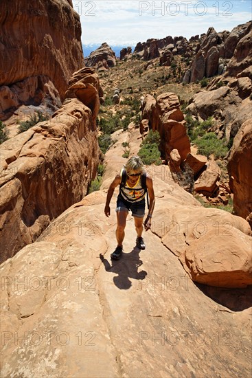 Hiker on a cliff in Devil's Garden