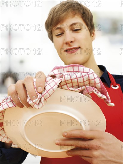 Young man wearing an apron while doing the housework