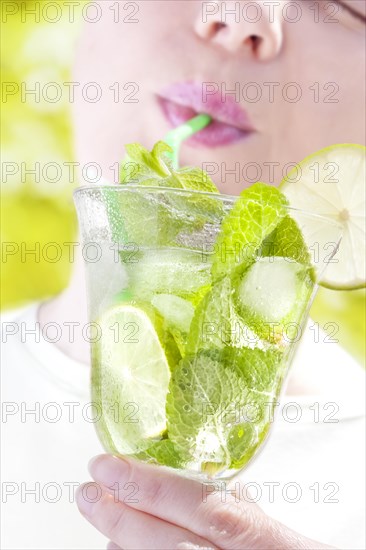 Woman drinking a Hugo cocktail with lime and mint