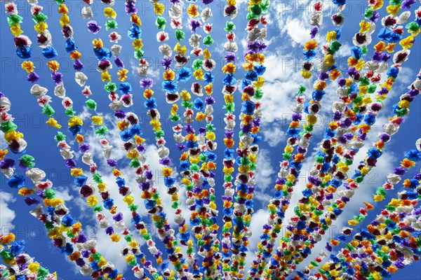 Colourful paper garlands against a blue sky