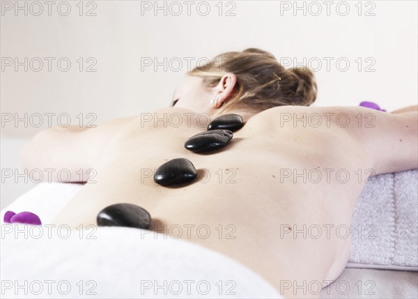 Young woman being treated with hot stones