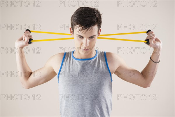 Young man doing fitness exercises with an expander