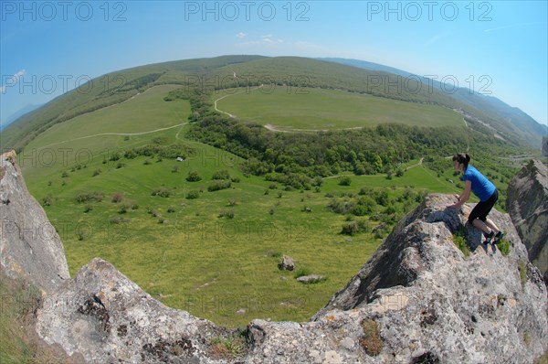 Woman looking down a cliff