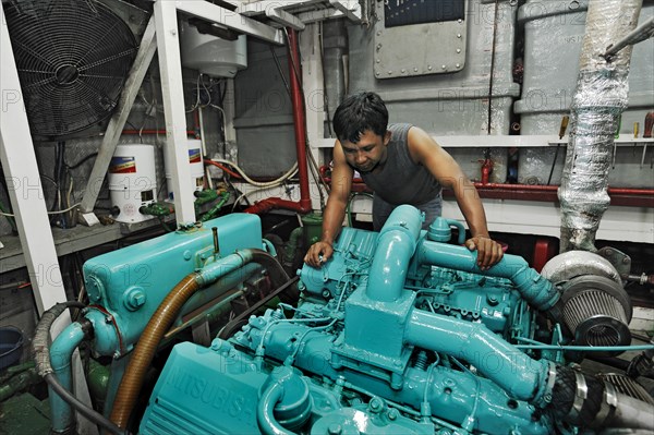 Machine operator in the engine room on the Buginese Schooner