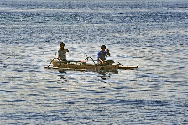 Two men in an outrigger boat