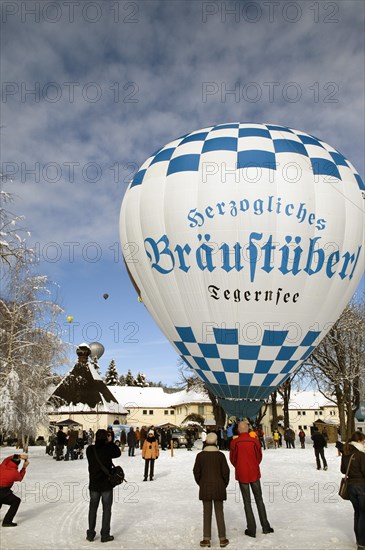 White and blue hot air balloon with advertising of 'Herzogliches Braeustuebel' restaurant