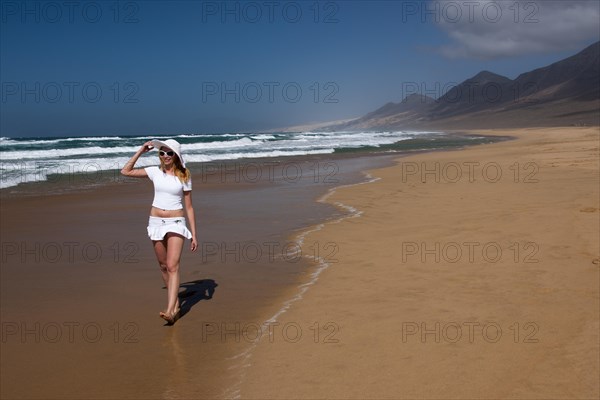 Woman walking along a sandy beach