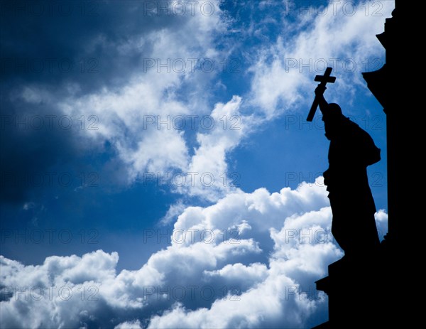 Silhouette of a sculpture holding a cross