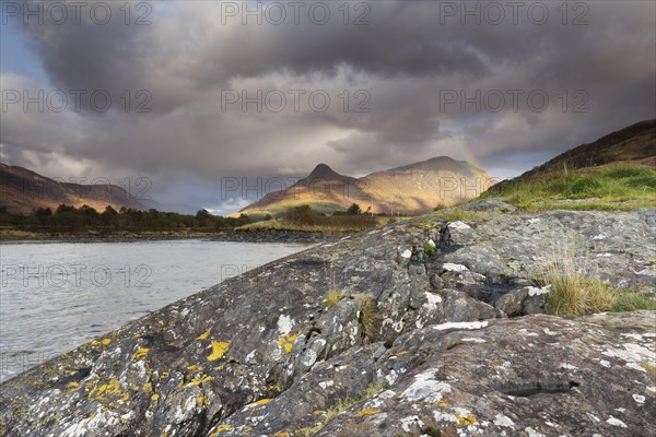 Rainbow arching over the Pap of Glencoe or Sgorr na Ciche during unsettled weather