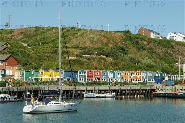 Sailing ship in the harbour of Heligoland or Helgoland in front of Hummerbuden or lobster shacks